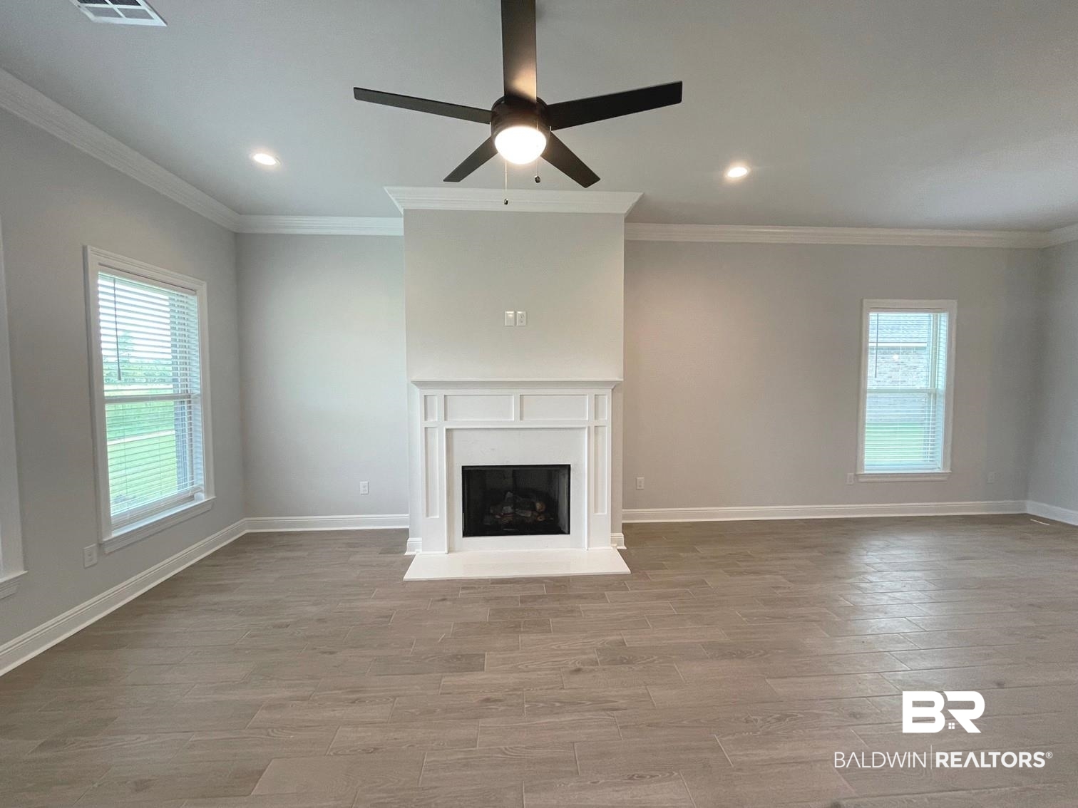 1642 Fenton Circle Foley, AL 36535 - Photo 5 of 14 Unfurnished living room featuring wood-type flooring, ceiling fan, and crown molding
