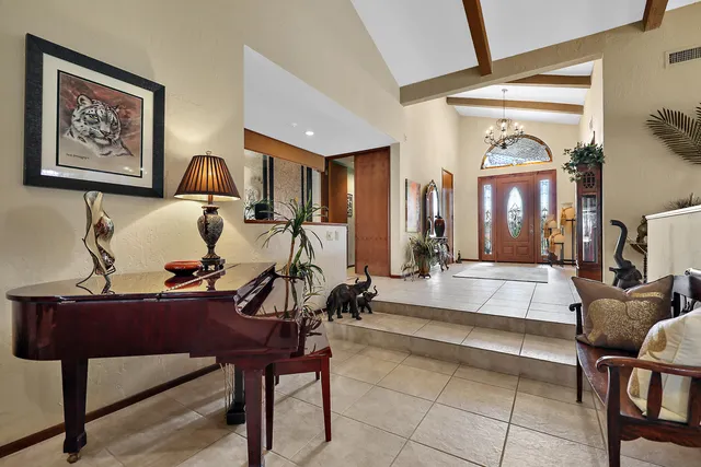 a living room with furniture a chandelier and a large window