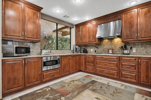 a kitchen with stainless steel appliances granite countertop a stove sink and cabinets