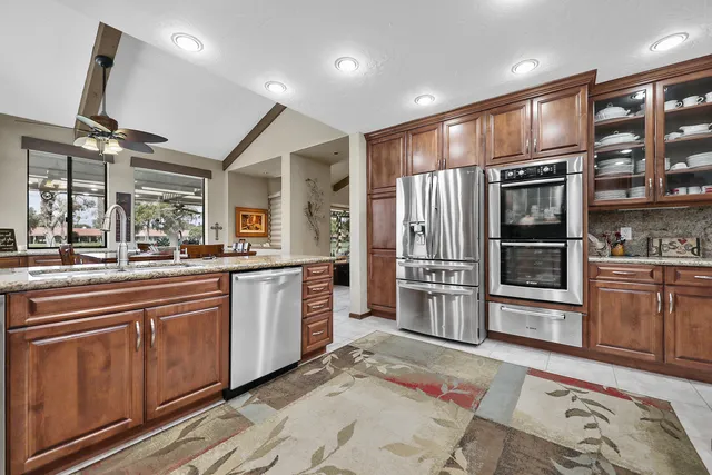 a kitchen with stainless steel appliances granite countertop a refrigerator and stove