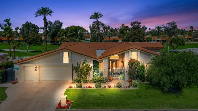 a front view of a house with a yard and green space