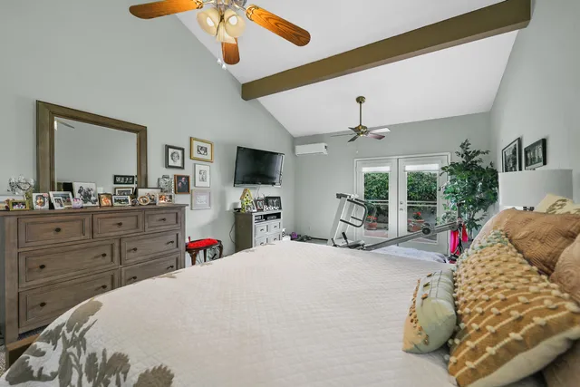 a bed room with a bed a flat screen tv and a chandelier