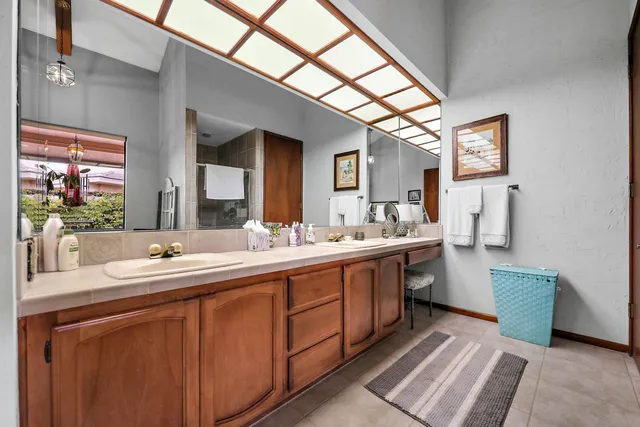 a bathroom with a double vanity sink mirror and bathtub