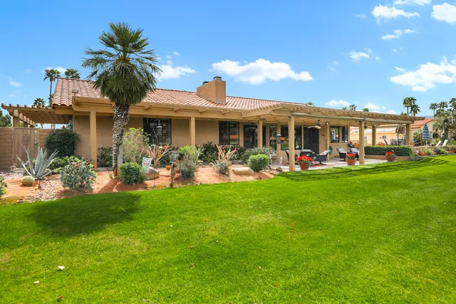 a front view of a house with a garden and plants