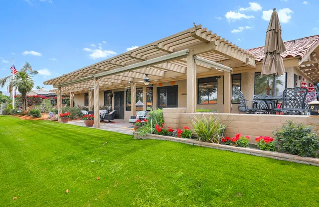 a front view of a house with a big yard and fountain