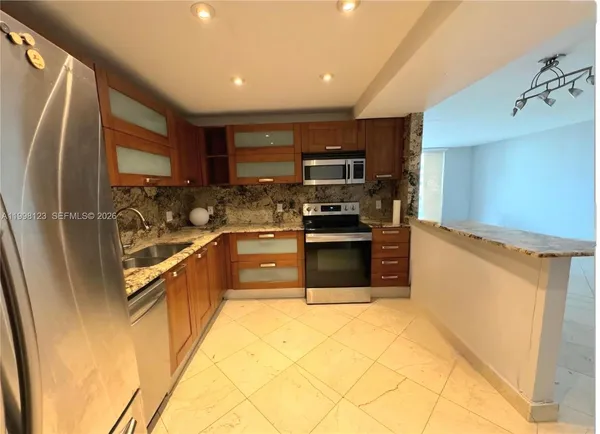 a kitchen with stainless steel appliances granite countertop a refrigerator and a sink