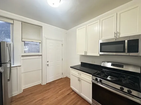 a kitchen with granite countertop a stove and a microwave