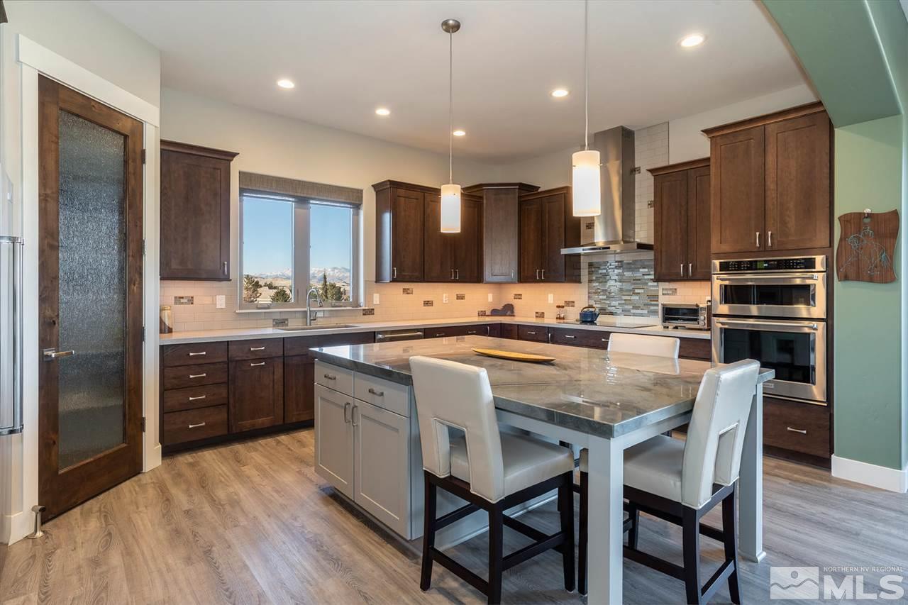 4920 Gila Bend Road Reno, NV 89511 - Photo 7 of 23 a kitchen with kitchen island granite countertop wooden cabinets and refrigerator