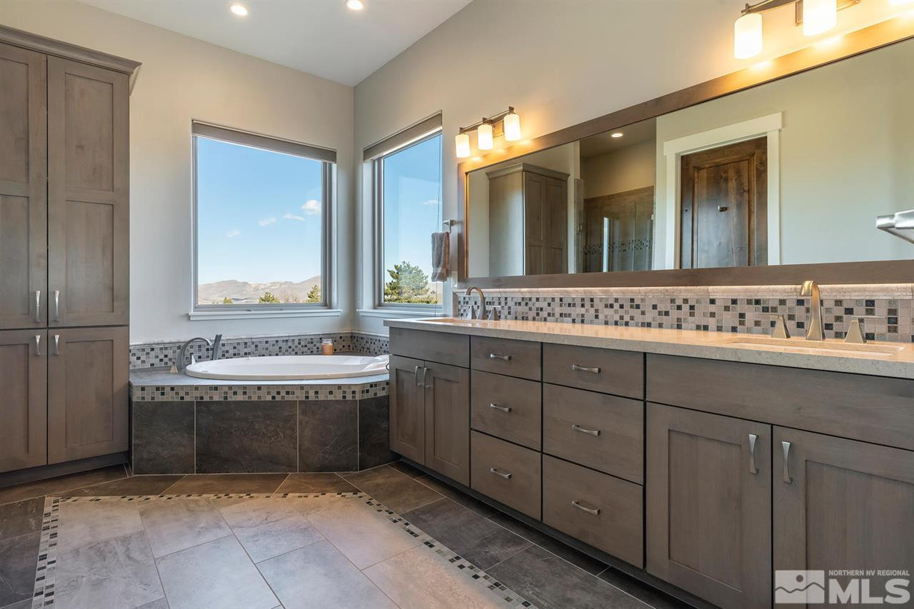 4920 Gila Bend Road Reno, NV 89511 - Photo 10 of 23 a bathroom with a granite countertop bathtub sink and mirror