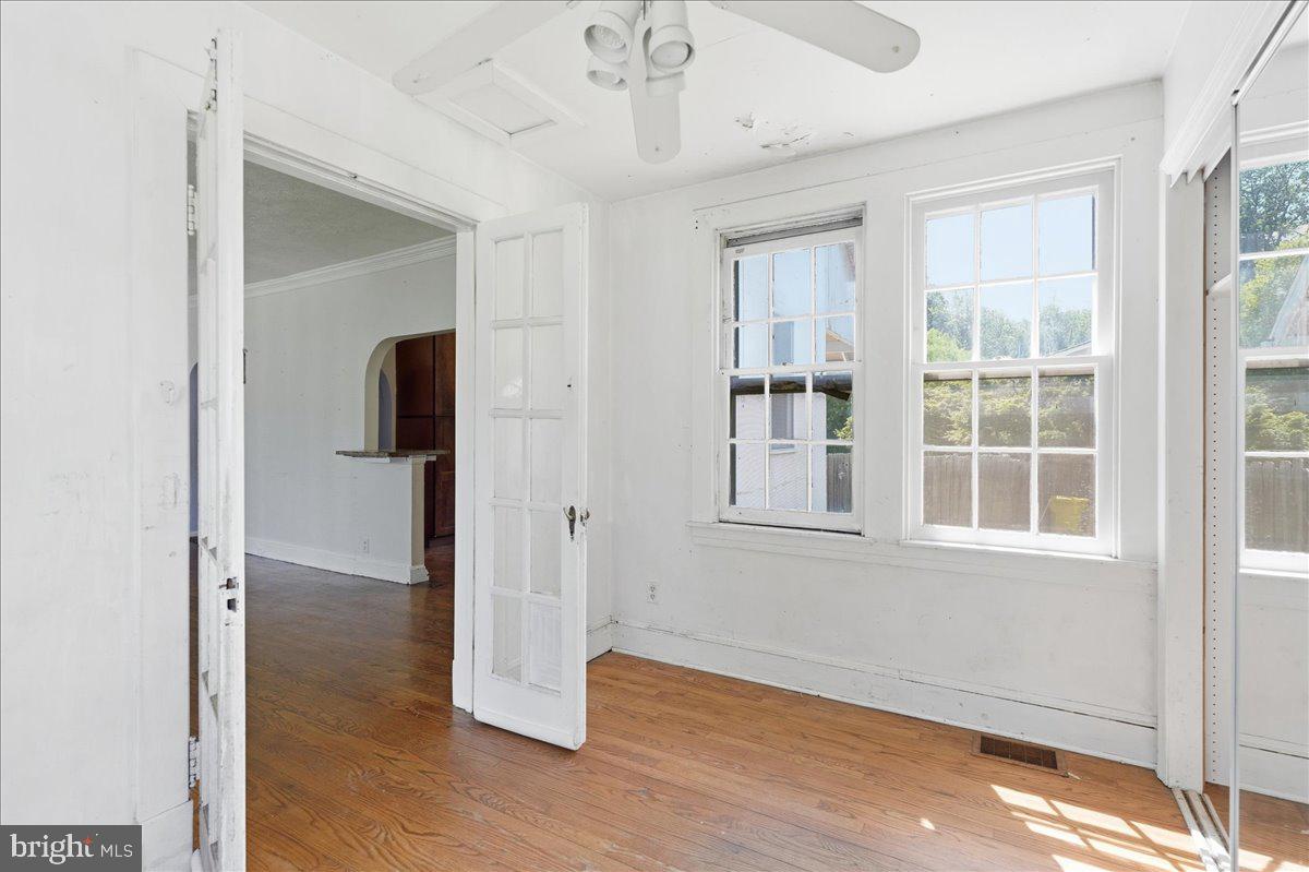 73 Church Road Arnold, MD 21012 - Photo 12 of 29 an empty room with wooden floor cabinet and windows