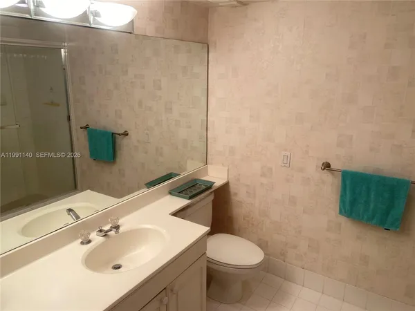 a bathroom with a sink a toilet and mirror