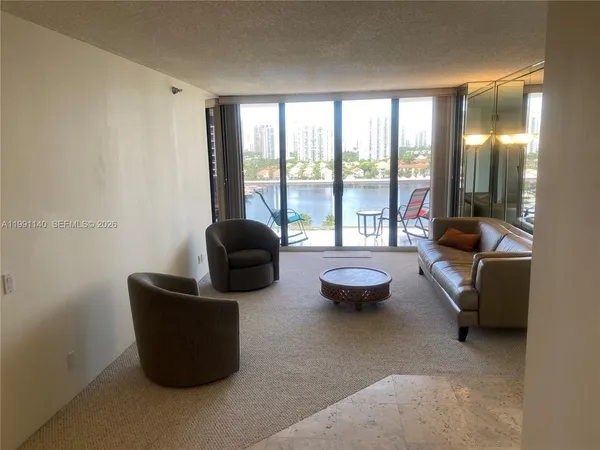 a living room with furniture and a floor to ceiling window