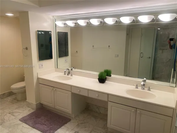 a bathroom with a double vanity sink toilet and a mirror
