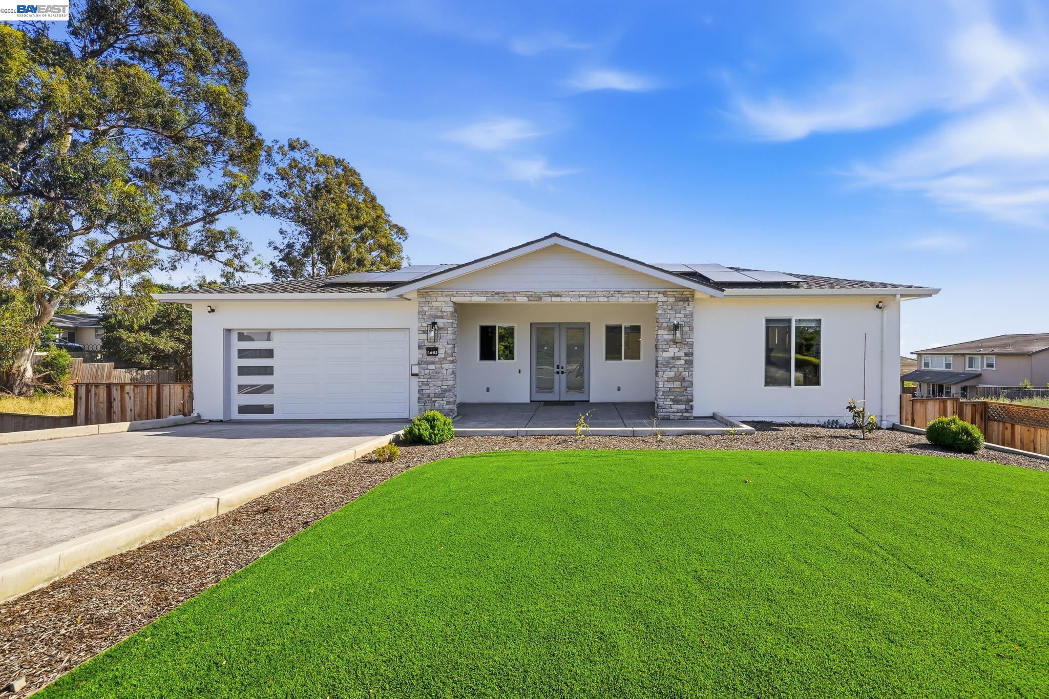 a front view of a house with a garden and patio