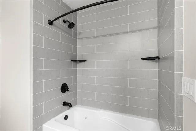 a bathroom with a tub sink and mirror