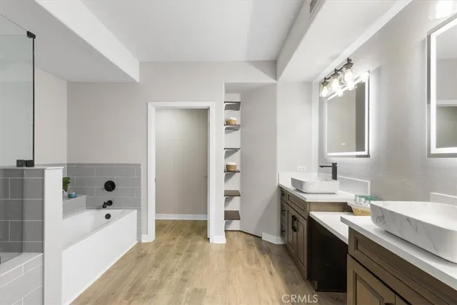 a bathroom with a granite countertop sink a large mirror and a bathtub