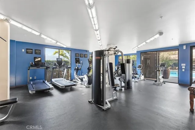 a view of swimming pool with outdoor seating and trees in the background