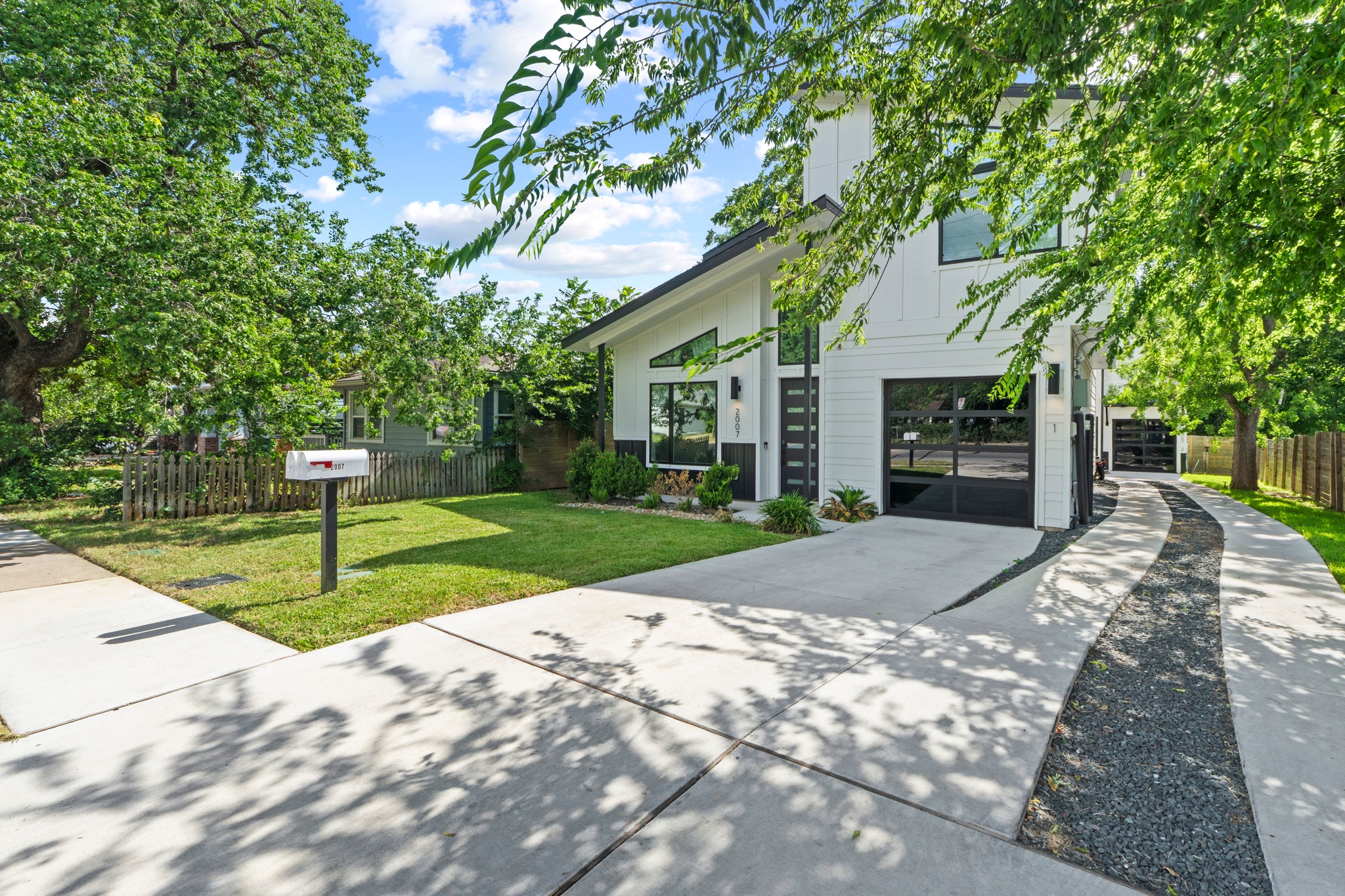 2007 Chestnut Avenue, Unit 1 Austin, TX 78722 - Photo 4 of 32 Modern architecture defines this dwelling, offering a striking street presence with mature shade trees.