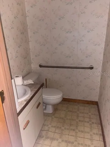 a bathroom with a granite countertop toilet and a sink
