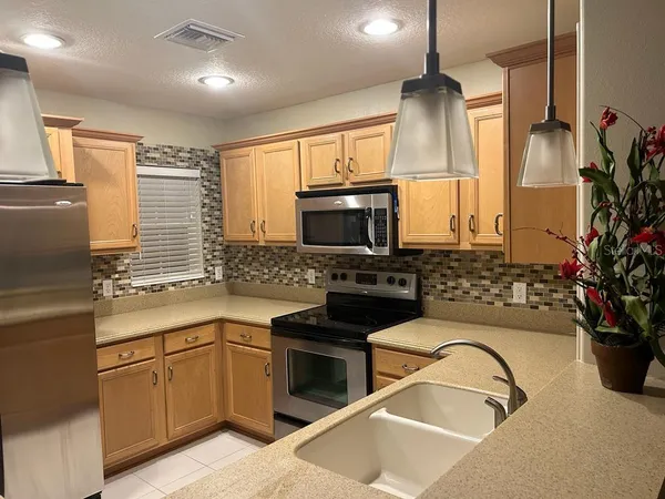 a kitchen with granite countertop a stove a sink and a microwave