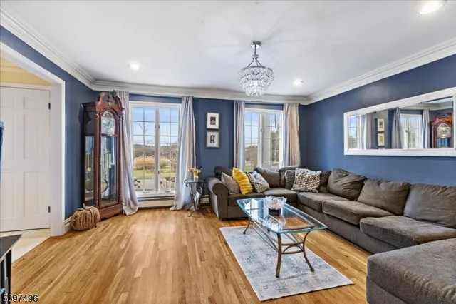 a living room with furniture flat screen tv and a large window