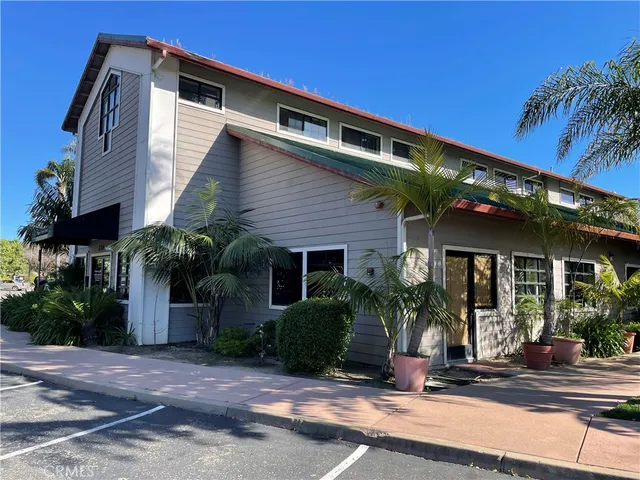 a front view of a house with plants