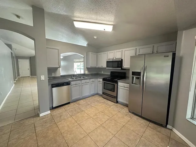 a kitchen with granite countertop a refrigerator and a sink