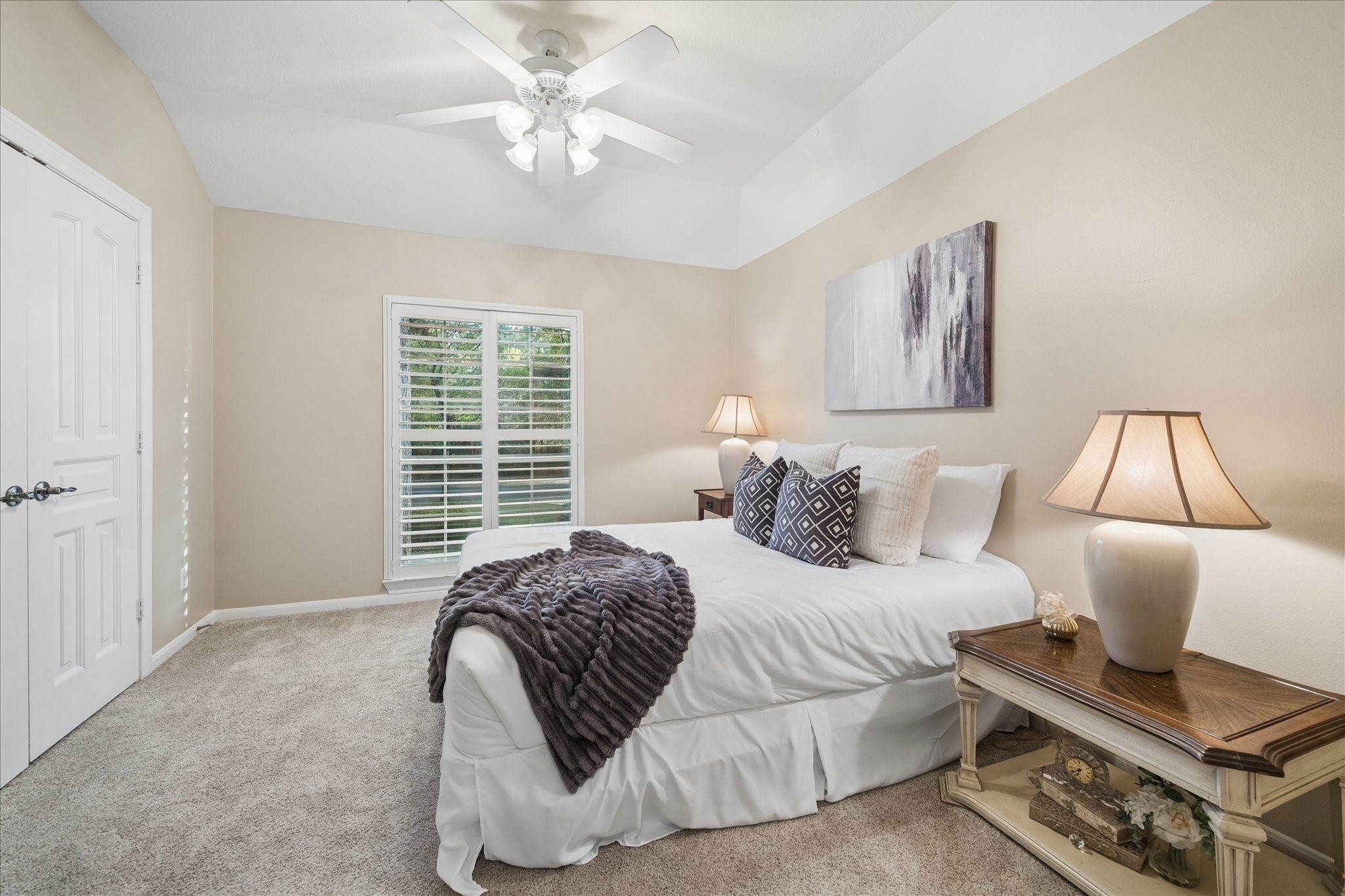 14530 Millhouse Road Pinehurst, TX 77362 - Photo 25 of 46 Upstairs bedroom featuring tray ceiling, carpeting, and window with plantation shutters providing natural light and views of the front grounds.