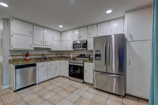 a kitchen with stainless steel appliances granite countertop a refrigerator stove a sink and microwave