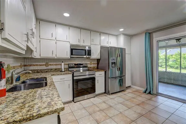 a kitchen with stainless steel appliances granite countertop a stove a sink and a refrigerator
