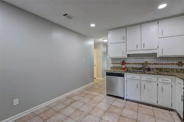 a kitchen with granite countertop white cabinets and white appliances