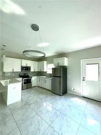 a kitchen with a refrigerator a stove a microwave and a counter space