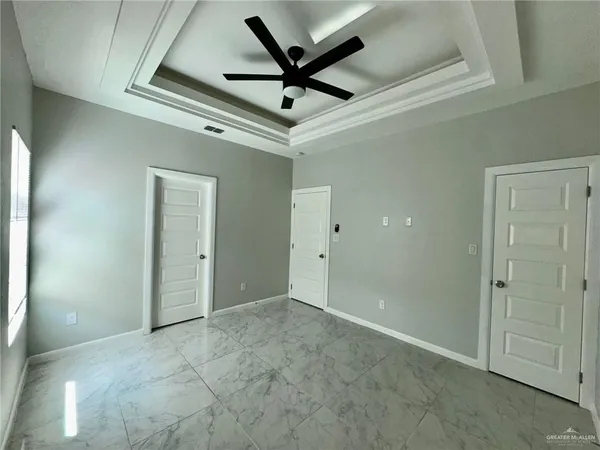 a view of a livingroom with a ceiling fan & kitchen space