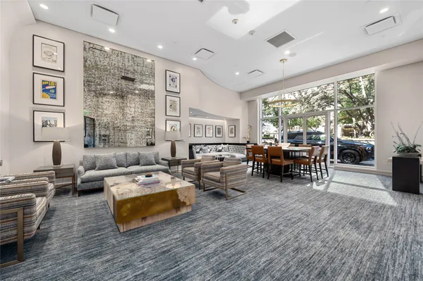 a living room with furniture large window and wooden floor