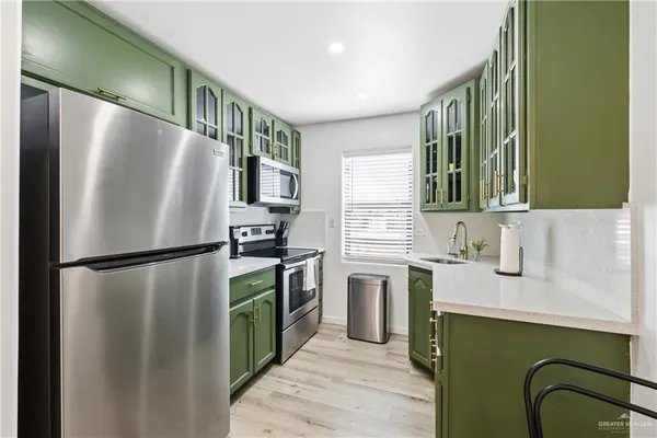 a kitchen with stainless steel appliances granite countertop a stove a sink dishwasher and cabinets with wooden floor