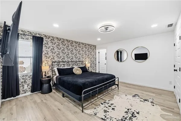 a bedroom with a bed and a flat screen tv