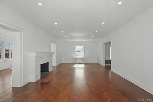 a view of an empty room with a fireplace and a window