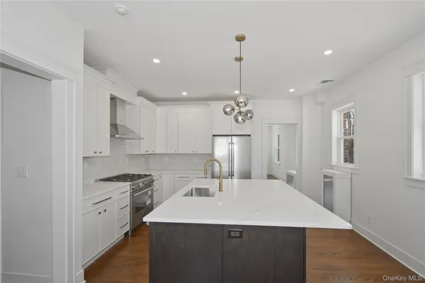 a kitchen with a sink stainless steel appliances cabinets and a counter top space