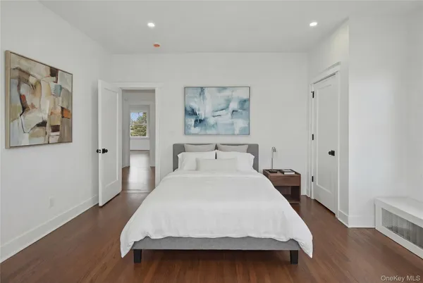 a spacious bedroom with a bed and a painting on the wall