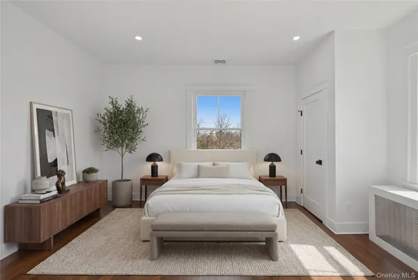 a bedroom with a large bed and windows