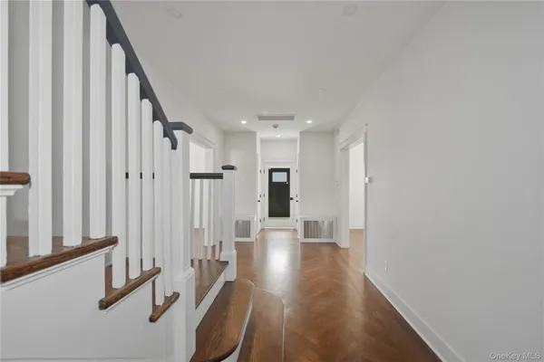 a view of a hallway with wooden floor and staircase