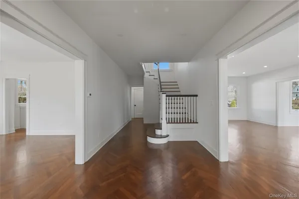 a view of a hallway with wooden floor and a window