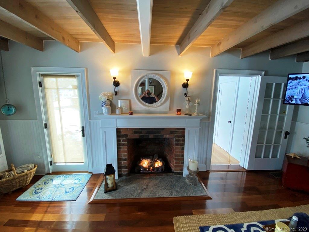 27 Brightwater Road Old Lyme, CT 06371 - Photo 18 of 34 a living room with wooden floor and a fireplace