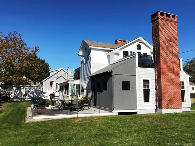 a front view of a house with a yard fire pit and chairs