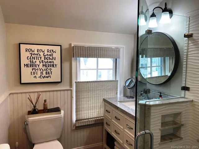 a bathroom with a toilet sink and mirror