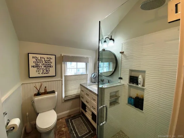 a bathroom with a toilet a sink and mirror