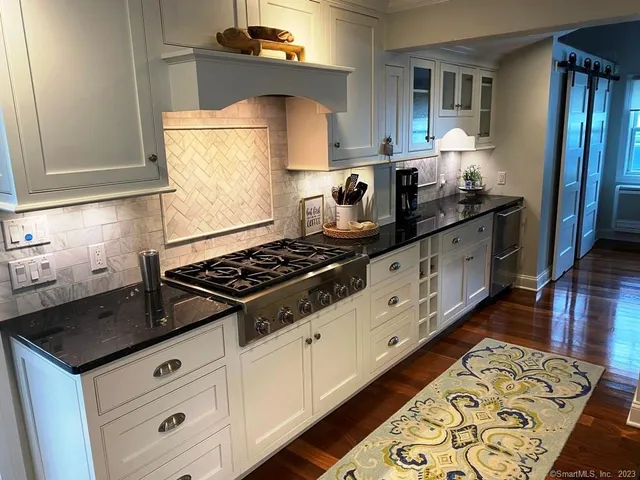 a kitchen with granite countertop a stove and a sink