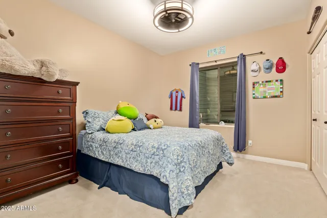 a bedroom with a large bed and a chandelier fan