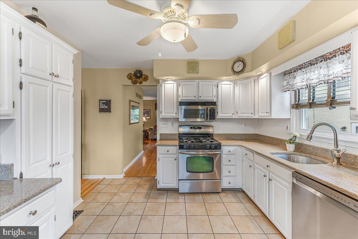 502 Ryanard Road Wallingford, PA 19086 - Photo 14 of 38 a kitchen with stainless steel appliances granite countertop a sink a stove a refrigerator cabinets and living room view