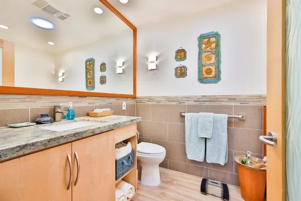 a bathroom with a granite countertop sink and a mirror